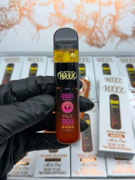 HITZ Mangoneda disposable vape box held by a gloved hand, set against a minimalist white backdrop.